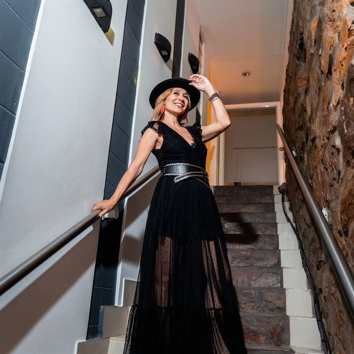 Vestido negro de tul con cinturón de tachas y sombrero
