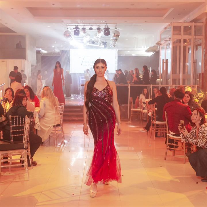 Modelo con vestido bordó caminando la pasarela